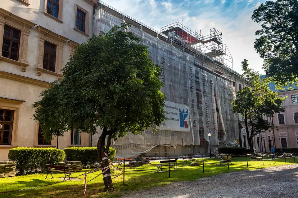 Rusztowanie osłonięte plandeką chroniącą świeżą elewację zabytkowego budynku przed pogodą